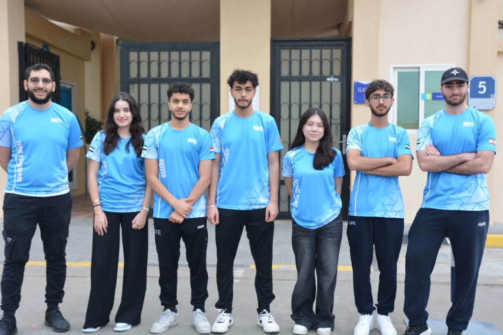 ANPS students in light blue school sports kit standing together outside a school building