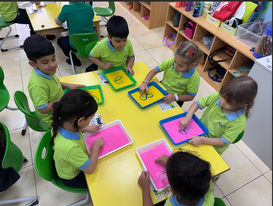 Children practising letter formation in tracing trays