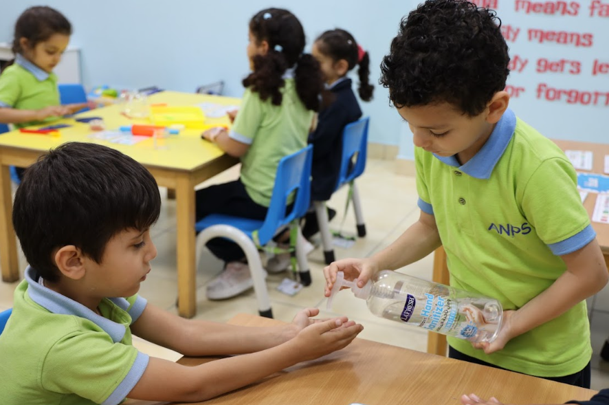 Child using hand sanitiser as part of a daily classroom routine